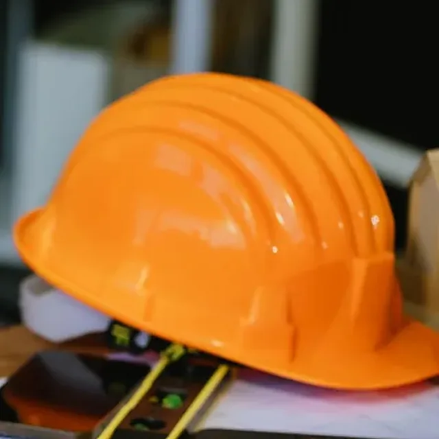Casco de seguridad naranja sobre una mesa de trabajo
